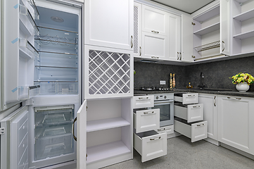 Image showing Open doors and drawers open at modern white kitchen