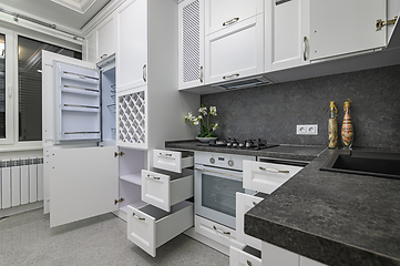 Image showing Open doors and drawers open at modern white kitchen