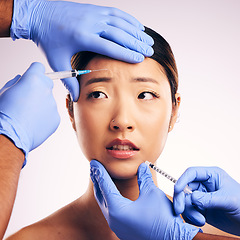 Image showing Woman, needle and worry on face in studio for surgery, stress and thinking for cosmetic results by background. Japanese model, girl and syringe for lip filler, anxiety or transformation for aesthetic