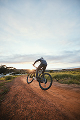 Image showing Sports, cycling and man on bicycle in countryside for training, workout and exercise in nature. Fitness, cyclist and person with mountain bike for adventure, freedom and ride on outdoor dirt road