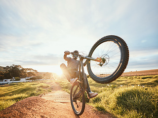 Image showing Sports, cycling trick and man on bicycle in nature for training, workout and exercise in countryside. Fitness, morning and cyclist on mountain bike for adventure, freedom and adrenaline on dirt road