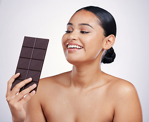 Image showing Chocolate, happy and face of woman in studio with luxury food, sweet treats and candy on white background. Wellness, calories and excited female person holding cocoa bar, sugar snack and dessert slab