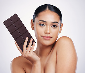 Image showing Chocolate, dessert and portrait of woman in studio with luxury food, sweet treats and candy. Wellness, calories and face of female person holding cocoa bar, sugar snack and slab on white background