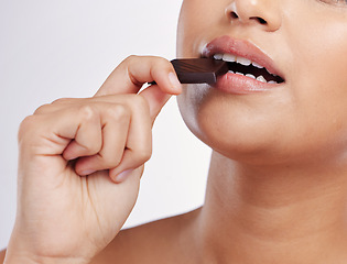 Image showing Chocolate, bite and mouth of woman with sweets in studio eating luxury food, treats and candy. Sugar, calories and face closeup of female person with cocoa bar, dessert and snack on white background