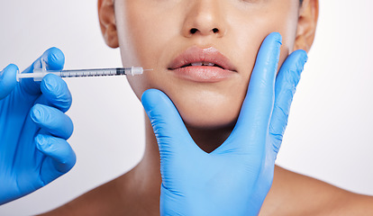 Image showing Hands, needle and face with collagen, studio and cosmetics surgery for beauty, change and lip filler by white background. Surgeon, syringe and facial transformation for woman, service and skincare