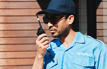 Image showing Security guard, walkie talkie and safety officer man outdoor for protection, patrol and communication. Law enforcement, serious and crime prevention worker with sunglasses, uniform and radio in city