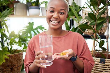 Image showing Portrait, water and medicine with a black woman in her home holding vitamins or supplements for health. Smile, glass and pills with a happy young female person drinking for wellness or hydration