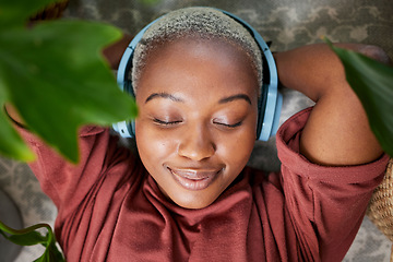 Image showing Woman, face and headphones for listening to music to relax on a floor with plants for peace and calm. Headshot of a black female person meditate with sound, audio and podcast or radio at home