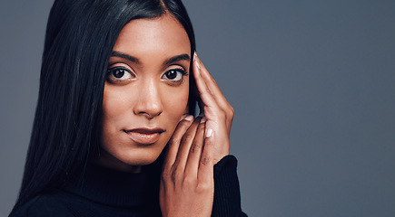 Image showing Face, skincare touch and confidence of woman in studio isolated on a gray background mockup space. Serious portrait, natural beauty and cosmetics of Indian model with facial treatment for aesthetic.