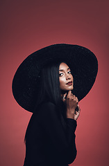 Image showing Portrait, fashion and confident woman with hat in studio isolated on red background mockup space. Face, style and serious model from India with makeup cosmetics, classy clothes and elegant aesthetic.