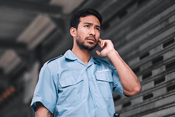 Image showing Security guard, serious and safety officer man on the street for protection, patrol or watch. Law enforcement, focus and duty with a crime prevention male worker in uniform to listen communication