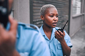 Image showing Security, walkie talkie and a police woman in the city during her patrol for safety or law enforcement. Radio, communication and service with an african female guard on a street in an urban town