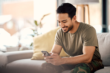 Image showing Happy, man and texting on cellphone in living room for online mobile app, scroll social media and notification on sofa. Asian male person typing on smartphone, contact and internet download at home