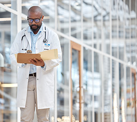 Image showing Black man, doctor and reading notes on clipboard with research documents, healthcare schedule or test results in hospital. Male medical worker, walking and planning report of insurance info in clinic