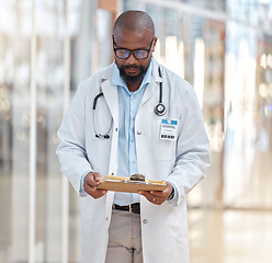 Image showing Black man, doctor and reading clipboard with documents of research, healthcare schedule and test results in hospital. Male medical worker with report of insurance, notes and planning info in clinic