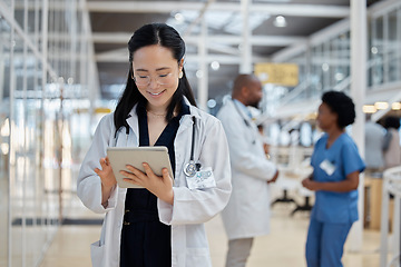 Image showing Doctor, asian woman and tablet for medical planning, data research and healthcare app in busy hospital. Happy female therapist, digital technology and consulting information for telehealth in clinic