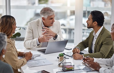 Image showing Businessman, laptop and teamwork with documents in meeting for strategy, planning or proposal at office. Corporate man, senior or CEO talking to team in leadership or training staff at the workplace