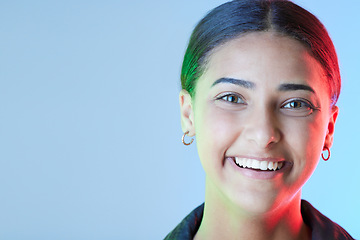Image showing Portrait, smile and mockup with a woman on a blue background in studio for a logo or branding. Happy, space for marketing or advertising and neon lighting on the face of a female brand ambassador