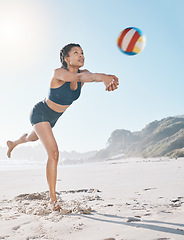 Image showing Woman, volleyball and hitting on beach in sports game, practice match or competition in the outdoors. Female person or player in volley or spiking ball up for fitness, point or athletics by the ocean