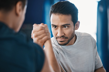 Image showing Arm wrestling, men and strength challenge with strong muscle at a gym for battle. Hand wrestle, power and male friends or athletes together for sport, competition or contest with focus and commitment