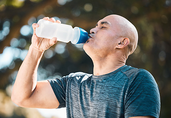 Image showing Man, drinking water and hydration in fitness after workout for nutrition, sustainability or thirst in nature. Tired and thirsty male person with healthy beverage for running, exercise or training