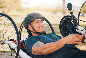 Image showing Cycling, fitness and man with disability in race, training for competition with smile, motivation and exercise on bike. Sports, workout and person on handcycle bicycle on outdoor track for challenge.