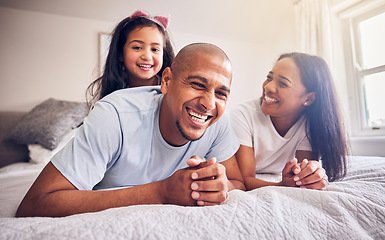 Image showing Mother, father and child laughing on a bed in a family home while happy and playing for quality time. Man, woman or parents and girl kid together in the bedroom for morning bonding with love and care