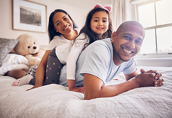 Image showing Family portrait, morning and relax on a bed at home while happy and playing for quality time. Man, woman or hispanic parents and a girl kid together in the bedroom for bonding with love and care