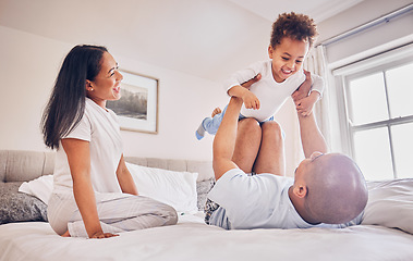 Image showing Happy family, playing and dad with child on bed, bonding and airplane game for father and daughter time in home. Parents, love and playful energy, man holding girl in air and mom laughing in bedroom.