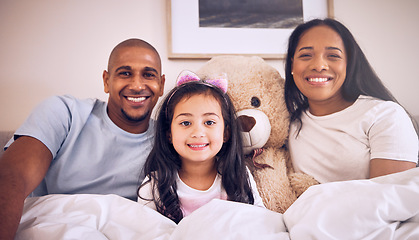 Image showing Family, morning and happy portrait on a bed at home with a smile, teddy bear and comfort for quality time. Man, woman or parents and a girl kid together in the bedroom for bonding with love and care