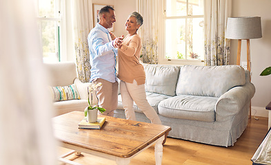 Image showing Love, retirement and dance with a senior couple in the living room of their home together for bonding. Marriage, romance or bonding with an elderly man and woman dancing in the lounge of their house