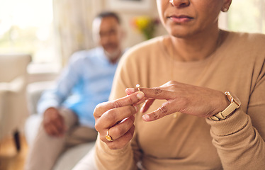 Image showing Senior woman, hands and ring in divorce, fight or conflict from disagreement or argument on sofa at home. Elderly couple in depression, infertility or cheating, mistake or toxic marriage in the house