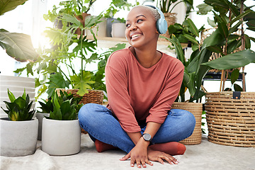 Image showing Music, relax and thinking with a black woman in her home by plants while streaming an audio playlist. Headphones, radio and subscription service with a happy young female person in her house