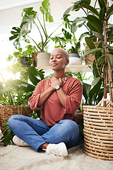 Image showing Meditation, plant and black woman relax in home for wellness, zen mindset and calm energy. Nature, happy and face of female person meditate on floor with eco friendly ferns, leaves and house plants