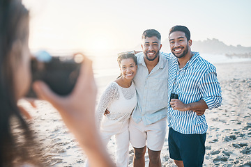 Image showing Happy, photo and friends at the beach with a photographer for summer memory, holiday or bonding. Smile, camera and a woman taking a picture of a group of people at the ocean during a vacation