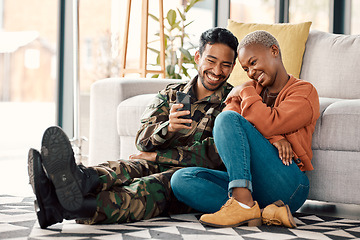 Image showing Army man, interracial couple and return with phone video on a sofa at home with love and care. Lounge, young people and mobile scroll in a house sitting on ground relax with travel picture of soldier