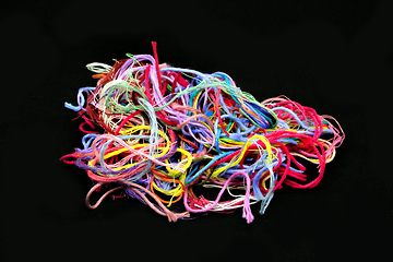 Image showing Ball of multicolored tangled threads for needlework on black bac