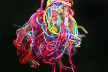 Image showing Multicolored tangled threads for needlework on black background