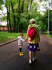 Image showing Mother and little curly toddler girl walking together in a park 