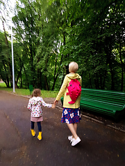 Image showing Mother and little curly toddler girl walking together in a park 