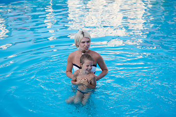 Image showing Happy mother and daughter playing in swimming pool