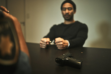 Image showing Interrogation, handcuffs and police with gun in jail for threatening, violence and hostage in station. Arrested, criminal and officer with weapon with man with anxiety, worry and scared in prison