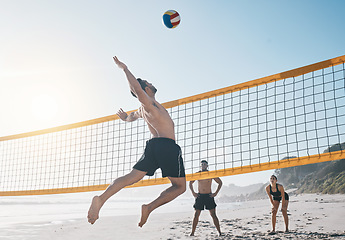 Image showing Man, jump and volleyball in air on beach by net in sports match, game or competition. Body of male person jumping for ball in volley or spike in healthy fitness, energy or exercise by the ocean coast