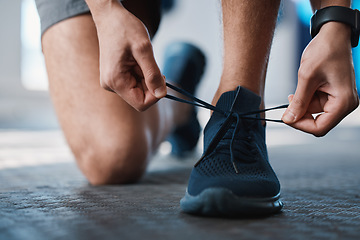 Image showing Fitness, shoes and tie with a sports man in the gym getting ready for a cardio or endurance workout. Exercise, running and preparation with laces of a male athlete or runner at the start of training