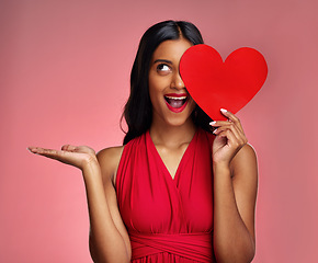 Image showing Woman, happy surprise and heart, advertising mockup in red dress and promotion of love on pink background. Valentines Day marketing, female model in lipstick and wow expression for branding in studio