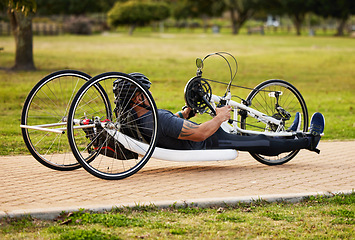 Image showing Health, cycling and fitness with man and handcycle on road for training, sports and challenge. Exercise, workout and marathon with person with a disability in park for cardio and wellness