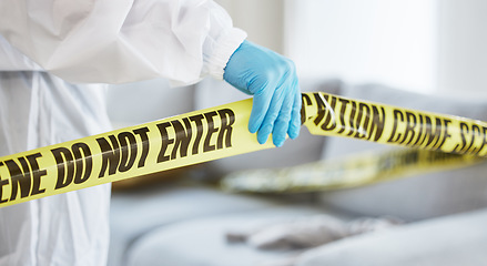 Image showing Forensics, crime scene and tape with investigator hand in house lounge for investigation, research or safety. Medical, science and evidence with closeup of person for examination, police and security