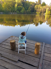 Image showing lonely little child fishing from wooden dock on lake