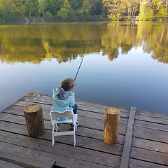 Image showing lonely little child fishing from wooden dock on lake