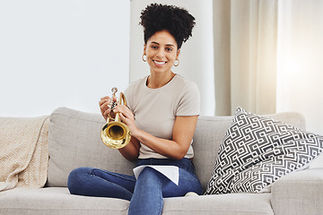 Image showing Portrait, woman and trumpet in home for music, learning and practice classic jazz song. Happy young female person, musician and brass horn instrument on sofa, living room and hobby of musical talent